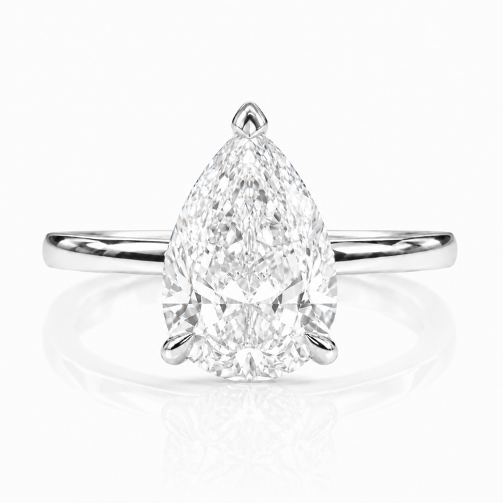 Solitaire engagement ring with a pear-shaped lab-grown center diamond in white metal, front view.
